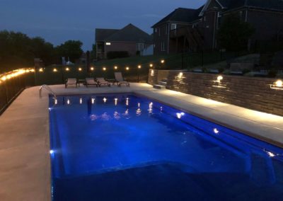 Beautiful pool and backyard at nighttime