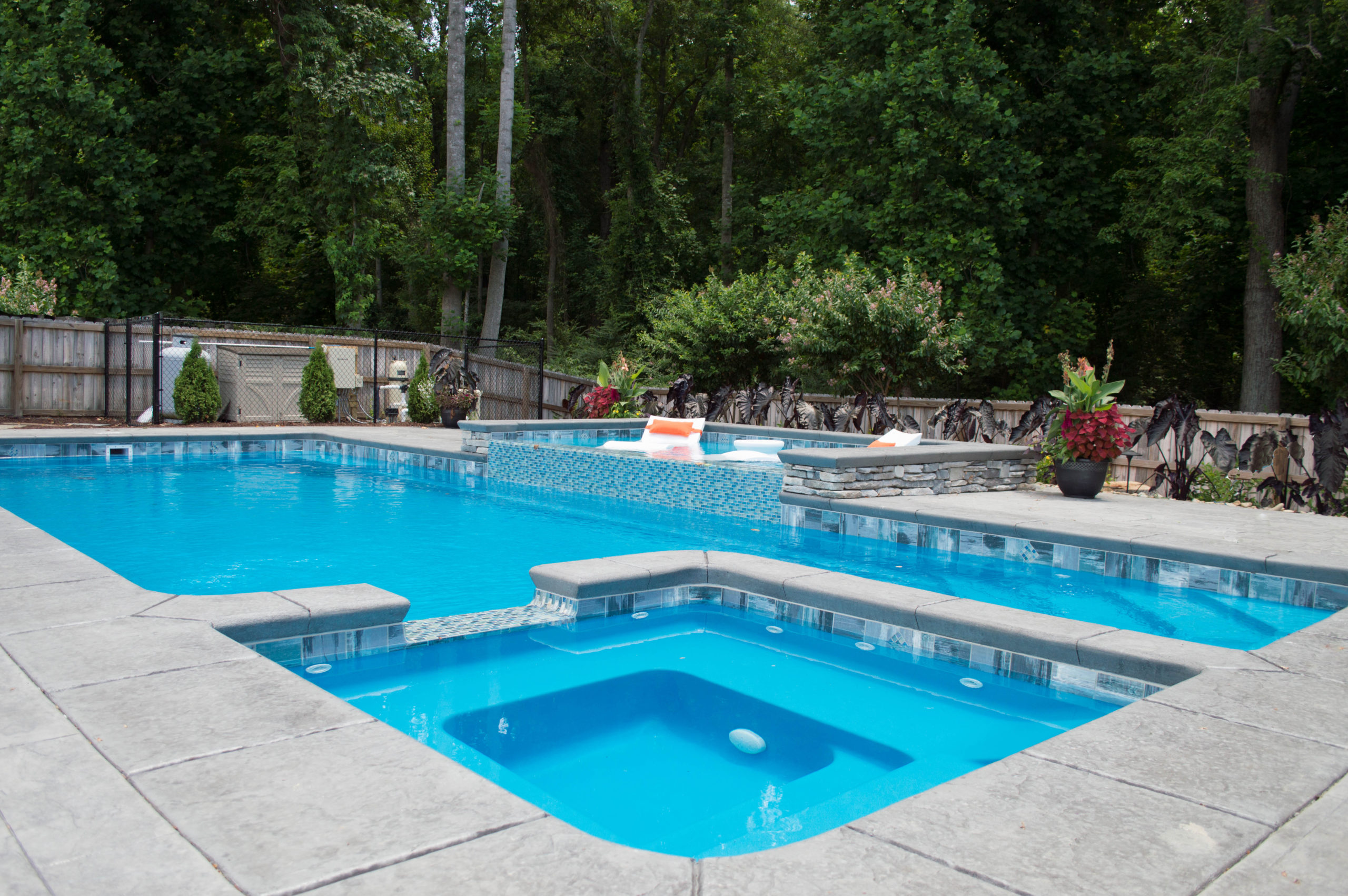 Picture of bright blue swimming pool and hot tub in ground